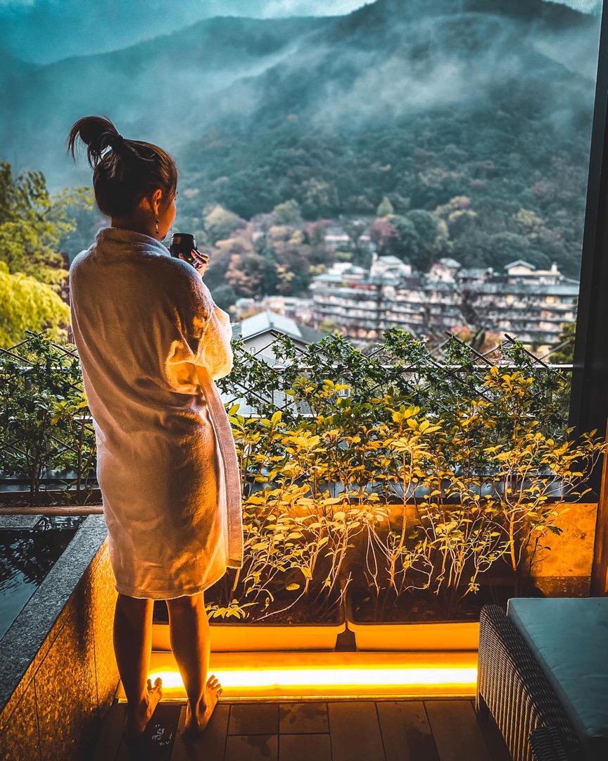 Figure at a lantern-lit terrace above a night valley